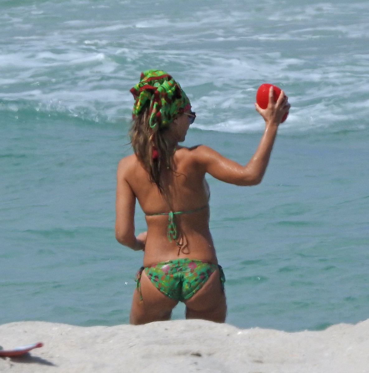 Jessica Alba en bikini verde con una pelota de rugby